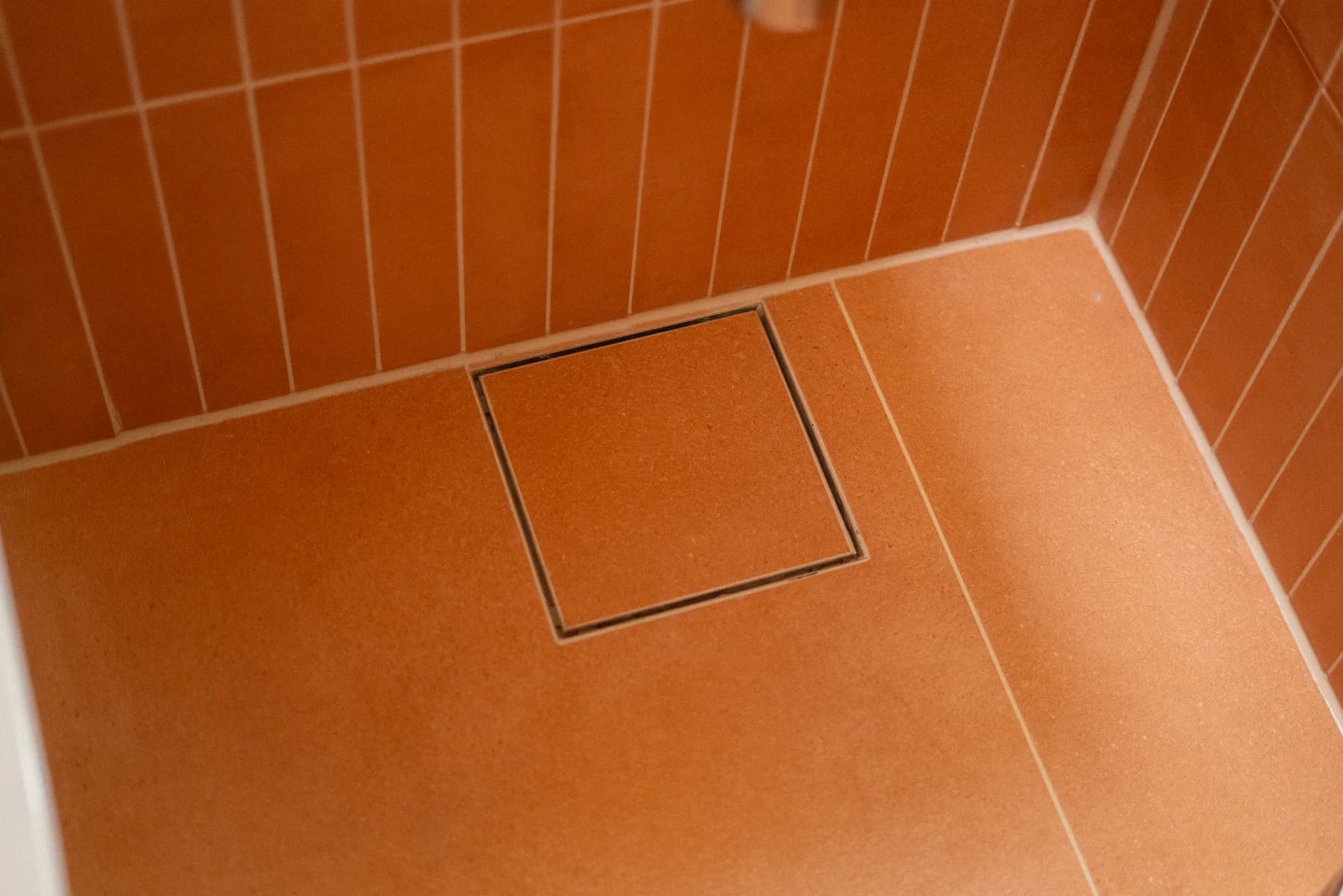 Detalj av tile insert-sluk i et flislagt baderom